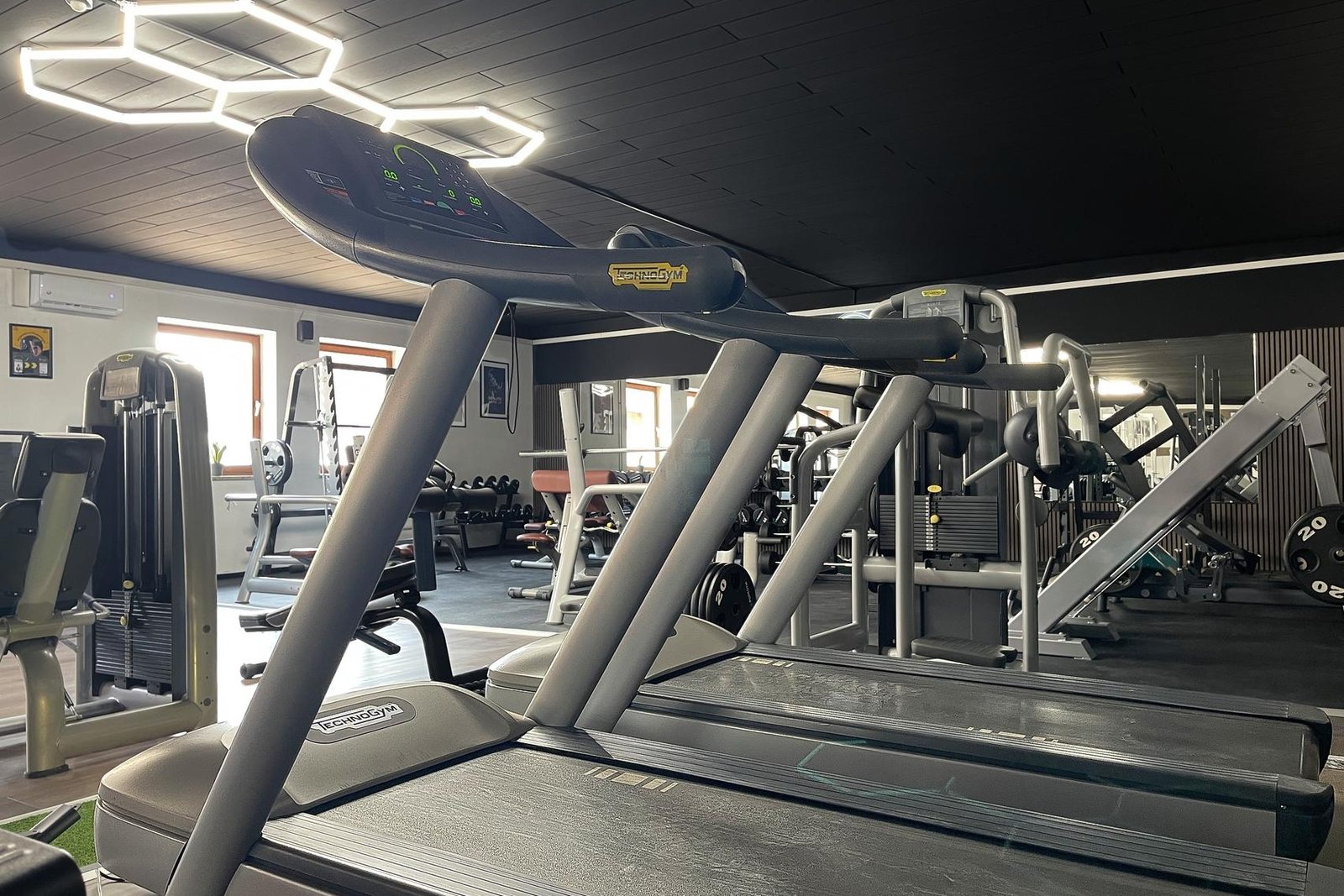 Cardio-Bereich mit Laufbändern unter Hexagon-Beleuchtung